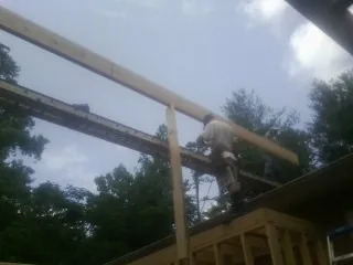 Carpenter setting a ridge beam over a new addition frame — Ice Dam Removal by Roofing Brothers in Big Timber