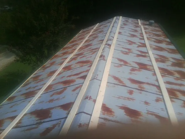 Rusted metal roof panels with new wood purlins before replacement — Storm Damage Roof Repair in Big Timber by Roofing Brothers