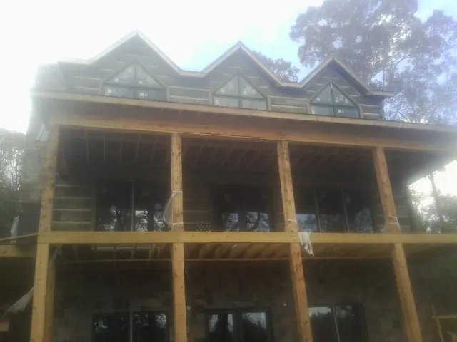 Dormers and porch framing on a large log home under construction — Roof Coating work by our crew in Big Timber