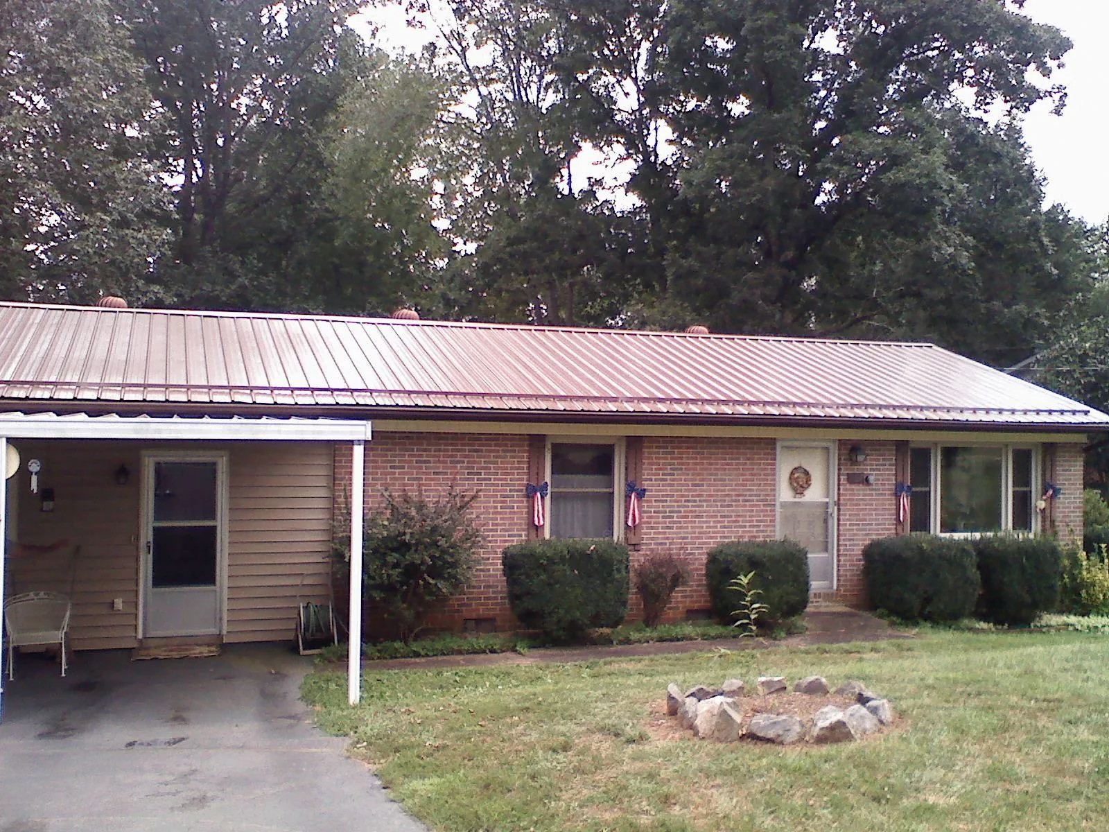 Bronze metal roof and carport on a brick ranch home — Roof Repair work by our crew in Big Timber